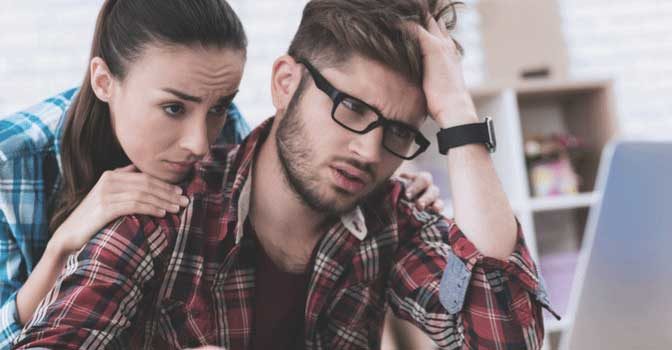 A couple looking at their private student loan default on a computer